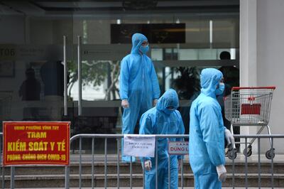 FILE PHOTO: Medical workers in protective suits stand outside a quarantined building amid the coronavirus disease (COVID-19) outbreak in Hanoi, Vietnam, January 29, 2021. REUTERS/Thanh Hue/File Photo