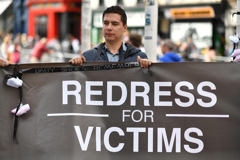 A protester holds a banner against abuse in the Catholic church. AFP