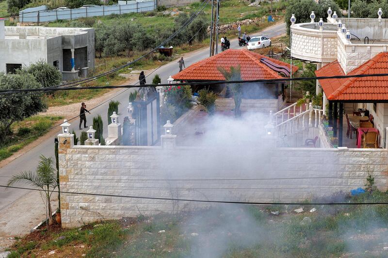Smoke billows after an explosive package left by Palestinians is detonated on a roadside in the occupied West Bank.