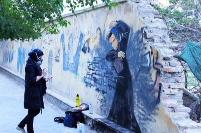 Shamsia Hassani working on one of her pieces on a Kabul wall. To minimise her time outdoors on the unsafe streets of Afghanistan she uses less details and colours. Picture courtesy of Shamsia Hassani 