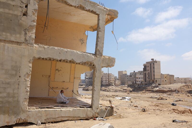 A volunteer rests inside a destroyed home. Reuters