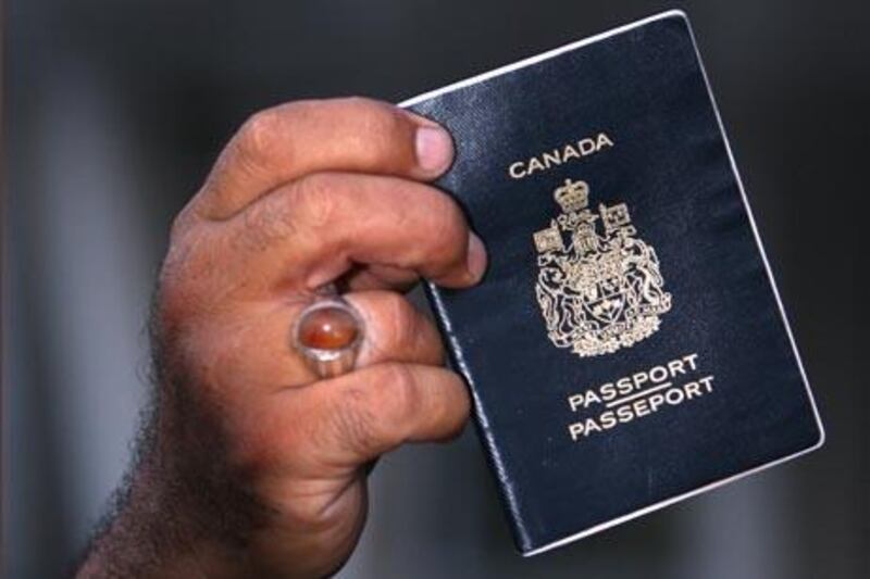 Sami Dia, an evacuee from Lebanon, displays his passport as Canadian passport holders fleeing the conflict in Lebanon arrive at the port of Mersin in Turkey's Mediterranean coastal city July 21, 2006.