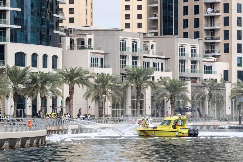 DUBAI, UNITED ARAB EMIRATES. 24 JANUARY 2020. Civil Defense extinguise the remains of a yacht that burnt out in the Dubai Marina. (Photo: Antonie Robertson/The National) Journalist: None. Section: Sport.

