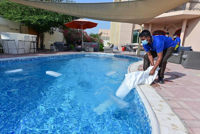 Employees of the Emirati company Gulf Ice Factory and Modern Ice Factory drop blocks of ice in a swimming pool in Dubai. AFP