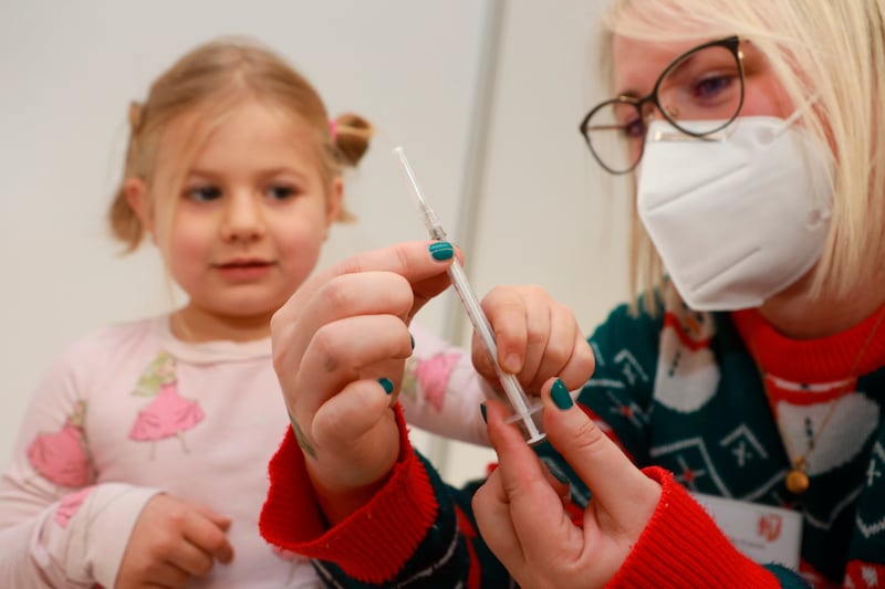 Five-year-old Charlotte from Timmenrode is shown a syringe by a vaccination assistant before her first Corona vaccination in Quedlinburg, Germany, December 18. AP