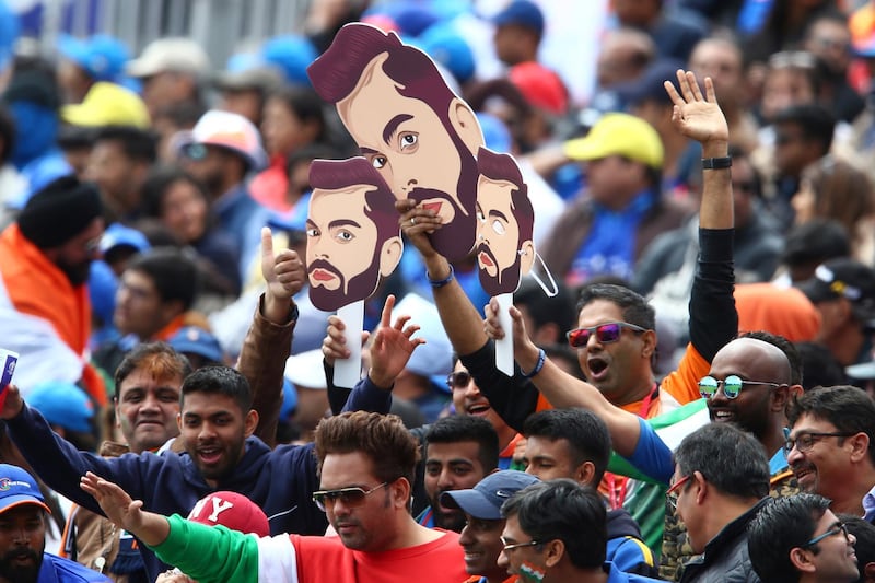 Indian cricket fans wear masks of India's captain Virat Kohli during the match. AP Photo