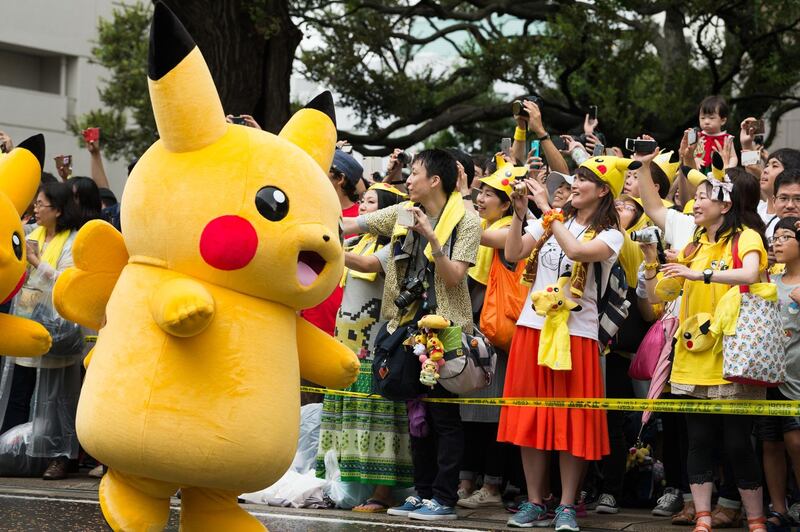 Audience members watch as performers dressed as the Pikachu character from Nintendo Co.'s Pokemon franchise march during the Pikachu Carnival Parade organised by Pokemon Co. in Yokohama, Japan, on Monday, Aug. 14, 2017. About 60 million people still play the Pokemon Go mobile game each month, according to data from mobile app research firm Apptopia, and one in five of those players opens the game on a daily basis. Photographer: Akio Kon/Bloomberg