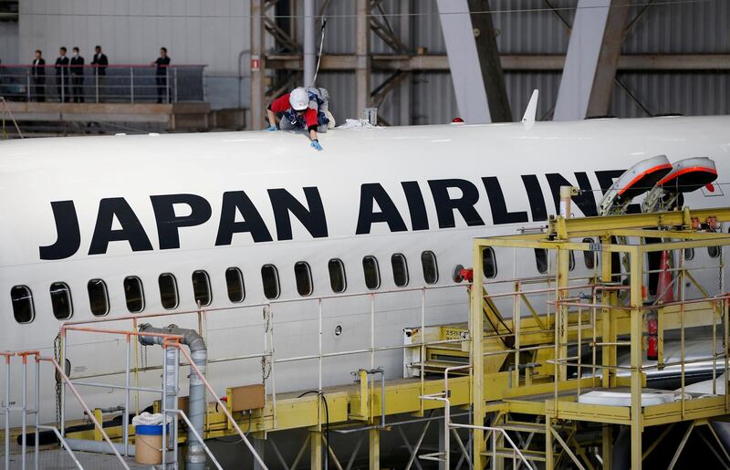 FILE PHOTO: A maintenance worker is seen atop of an airplane of Japan Airlines (JAL) at a hangar of Haneda airport in Tokyo, Japan, April 2, 2018.  REUTERS/Issei Kato/File Photo                   GLOBAL BUSINESS WEEK AHEAD