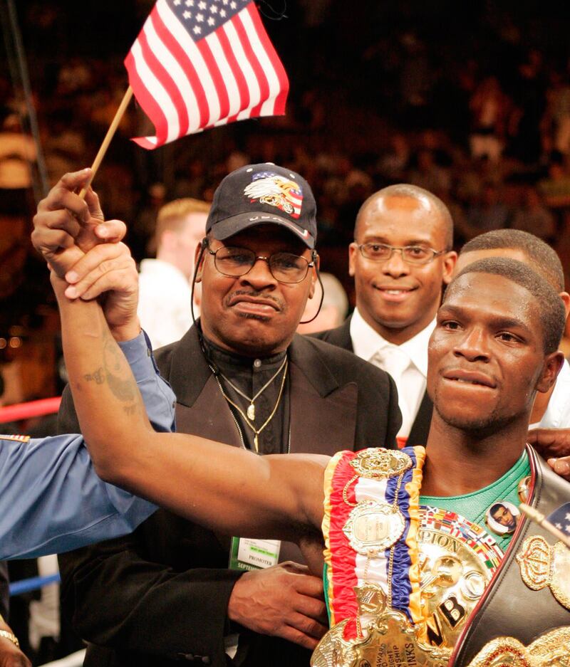 Leon Spinks looks on as his son Cory Spinks dons the title belt and waves an American flag after defeating Miguel Angel Gonzalez of Mexico to retain the welterweight boxing title in Las Vegas in 2004. EPA