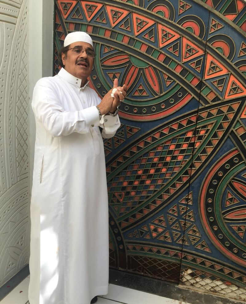 Ali Al Ruzaiza at the door to his home, which he carved and painted himself. It doesn't have a doorknob and one must knock to get in. Melissa Gronlund  