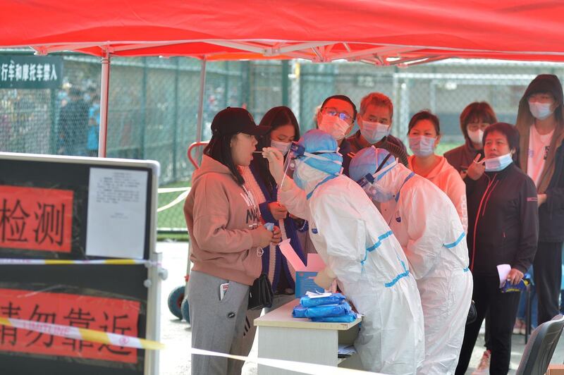 Medical workers in protective suits collect swabs for nucleic acid tests during a city-wide testing following new coronavirus disease (COVID-19) cases in Qingdao, Shandong province, China October 12, 2020. cnsphoto via REUTERS   ATTENTION EDITORS - THIS IMAGE WAS PROVIDED BY A THIRD PARTY. CHINA OUT.