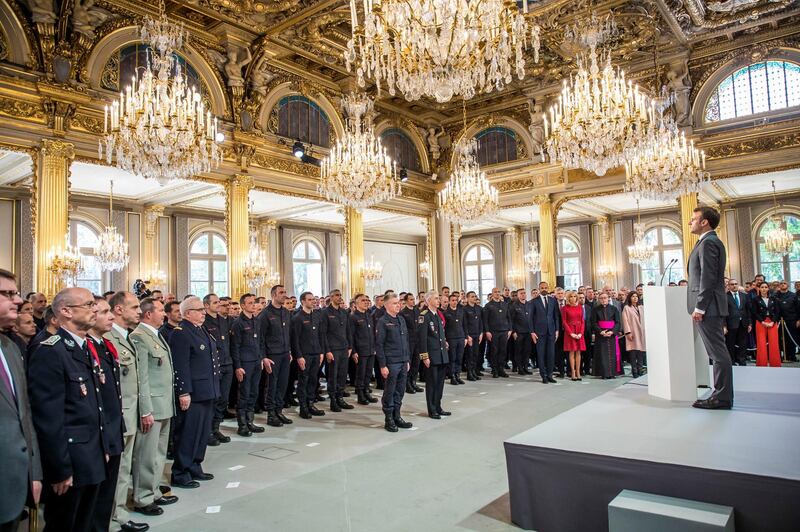 French President Emmanuel Macron stands at attention after addressing Paris Firefighters' brigade and security forces who took part at the fire extinguishing operations of the Notre Dame of Paris Cathedral fire, at the Elysee Palace in Paris, Thursday, April 18, 2019. France paid a daylong tribute Thursday to the Paris firefighters who saved the internationally revered Notre Dame Cathedral from collapse and rescued many of its treasures. AP