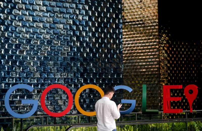 epa08257757 (FILE) - A man uses his mobile phone while walking past the Google logo in Singapore, 06 December 2019 (reissued 29 February 2020). Google has expanded travel restrictions on employees after a person tested positive for coronavirus at the company's Zurich. According to media reports, by March employees will see restrictions on traveling to Japan, South Korea, China, Iran and parts of Italy.  EPA/WALLACE WOON