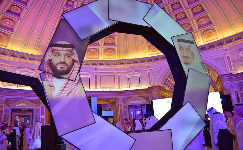 Pictures of Saudi Crown Prince Mohammad Bin Salman (L) and King Salman (R) are displayed during the first session of Saudi Arabia's National Industrial Development and Logistics Program (NIDLP) at the Ritz Carlton in Riyadh on January 28, 2019. / AFP / FAYEZ NURELDINE
