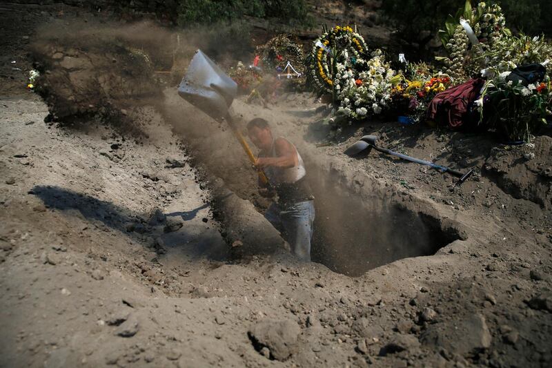 A worker digs a new grave  at the Valle de Chalco Municipal Cemetery on the outskirts of Mexico City. AP Photo