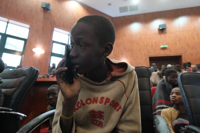 A child speaks on the phone while gathering at the Government House with other students from the Government Science Secondary school.  AFP