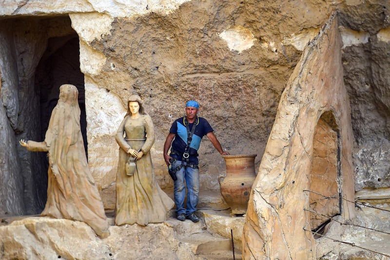 Polish artist Mario, sculptor of St. Simon the Tanner Monastery complex, poses for a picture alongside sculptures at the church in the Egyptian capital Cairo's eastern hillside Mokattam district. Mario spent more than two decades carving the rugged insides of the seven cave churches and chapels of the rock-hewn St. Simon Monastery and church complex atop Cairo's Mokattam hills, with designs inspired by biblical stories. It was all done to fulfil the wishes of the church's parish priest who met Mario in the early 1990s in Cairo. The Polish artist, who had arrived in Egypt earlier on an educational mission, was then looking for an opportunity to serve God at the monastery.  AFP