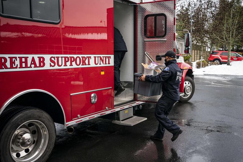 Keenan Miles of the Shoreline Fire Department loads gear into a vehicle as his mobile Covid-19 vaccination team prepares to visit adult family homes in Shoreline, Washington. AFP