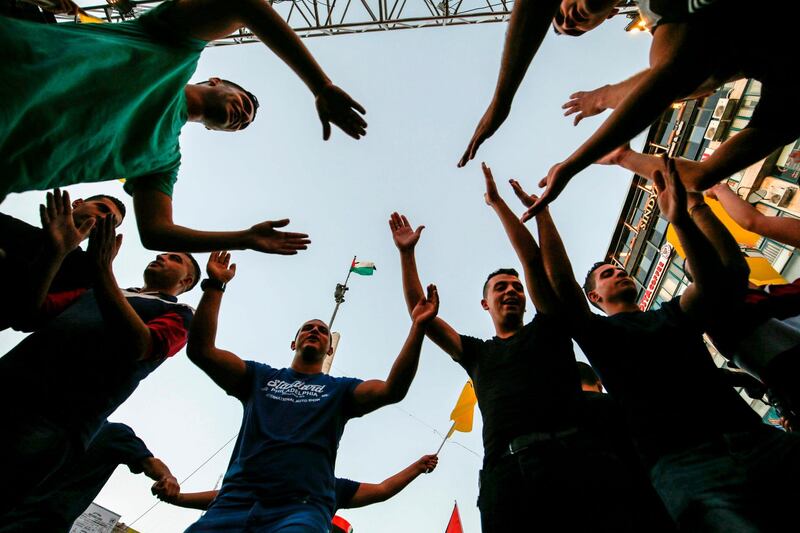 Palestinians chant slogans and wave pictures of Abbas during a demonstration in Ramallah. AFP