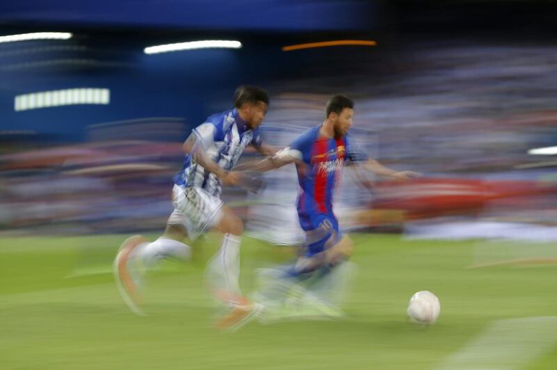 Barcelona’s Lionel Messi, right, is challenged by Alaves’ Theo Hernandez. Daniel Ochoa de Olza / AP Photo
