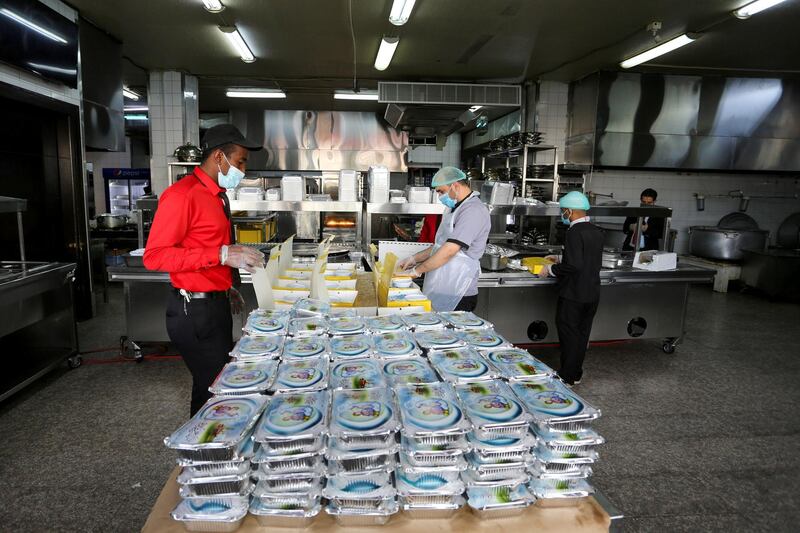 Kitchen staff wear protective face masks and gloves, following the outbreak of the coronavirus disease (COVID-19), as they prepare Ramadan meal orders for takeaway and delivery at a restaurant in Riyadh, Saudi Arabia, April 26, 2020. Picture taken April 26, 2020. REUTERS/Ahmed Yosri