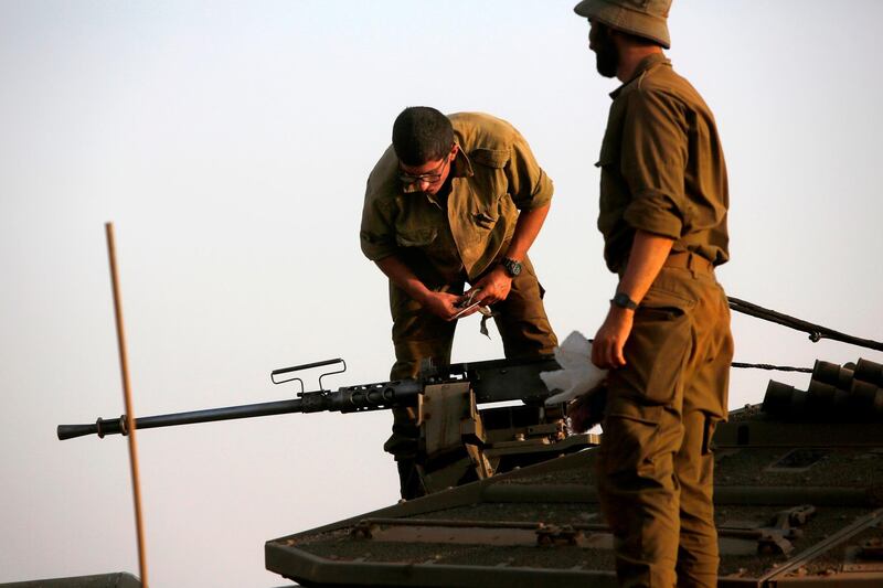 An Israeli soldier checks on a machine gun turret atop a Merkava battle tank stationed in the Israeli-annexed Golan Heights on July 28, 2020, as the army reinforces and updates forces at its northern command.  / AFP / JALAA MAREY
