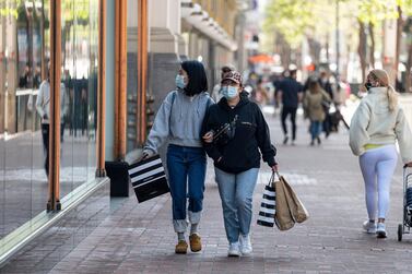 Shoppers wearing protective masks carry bags on Market Street in San Francisco, California. Bloomberg