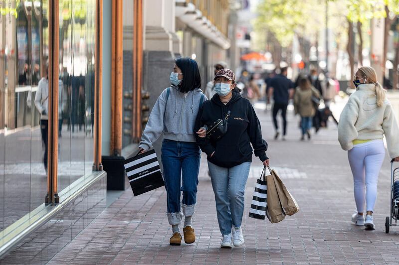 Shoppers wearing protective masks carry bags on Market Street in San Francisco, California, U.S., on Wednesday, April 14, 2021. U.S. retail sales probably swelled in March thanks to faster hiring, the distribution of federal stimulus checks, a steady pace of Covid-19 vaccinations and fewer restrictions on stores across the country. Photographer: David Paul Morris/Bloomberg