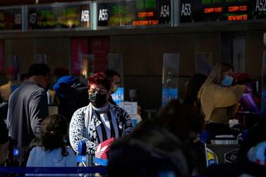 Travellers wear face masks as they check in for an international flight in Los Angeles, California. AFP