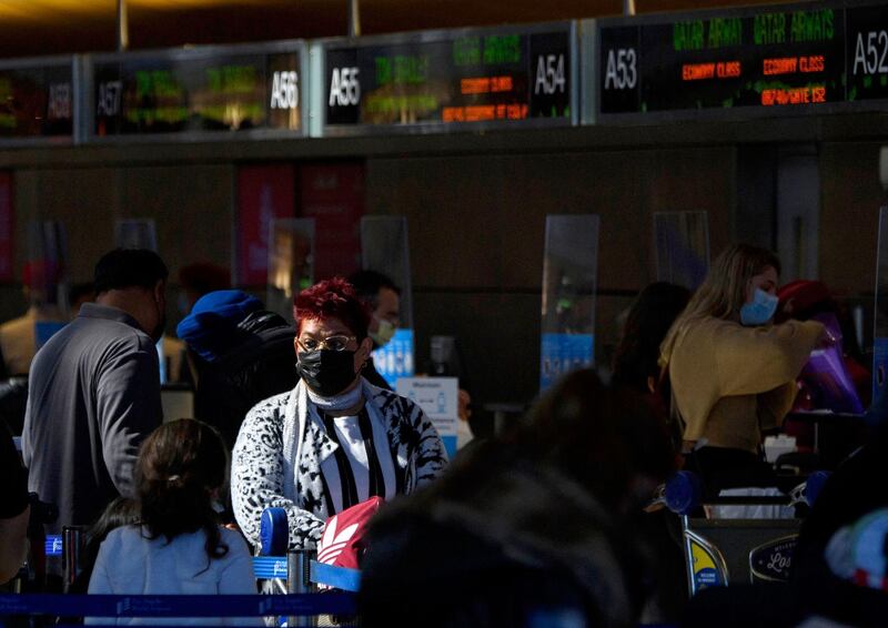 (FILES) In this file photo taken on February 04, 2021, travelers wear face masks as they check-in for a Qatar Airways flight at the Tom Bradley International Terminal at Los Angeles International Airport in Los Angeles, California. The US on June 8, 2021, eased its warning against travel to a number of major nations including Olympics host Japan, Canada, France and Germany after reassessing Covid concerns. The State Department issued an advisory asking Americans to reconsider travel due to the risk of Covid-19, upgrading a blanket warning earlier not to go. / AFP / Patrick T. FALLON
