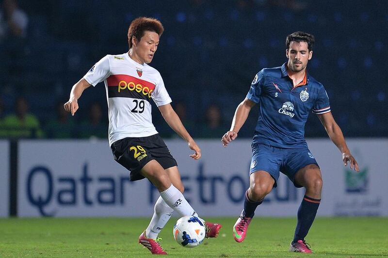 Lee Myung-joo, left, of Pohang Steelers shields the ball from David Rochenla of Buriram United during their AFC Champions League match at Buriram Stadium on March 11, 2014, in Buriram, Thailand. Asian players such as Lee may soon lose the places reserved for players from the continent on Arabian Gulf League teams. Thananuwat Srirasant / Getty Images