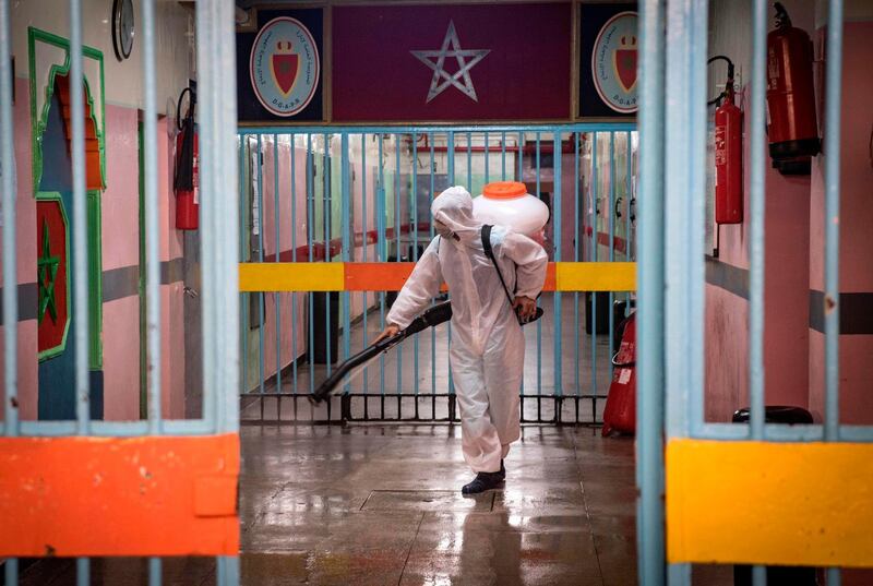 An inmate, wearing personal protective equipment, disinfects a hall at the Oukacha prison in Casablanca.   AFP