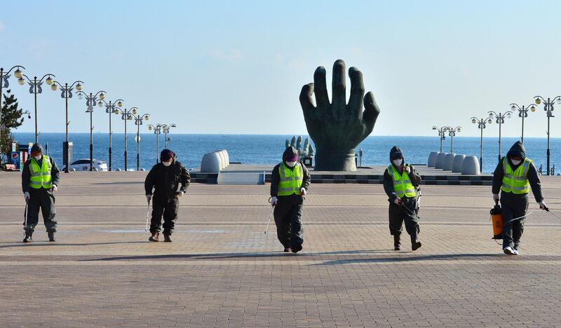 Quarantine workers disinfect a plaza at Cape Homi, a popular point where the sunrise can be viewed earlier than other locations on the Korean Peninsula, on the coast of Pohang in southeastern South Korea. EPA