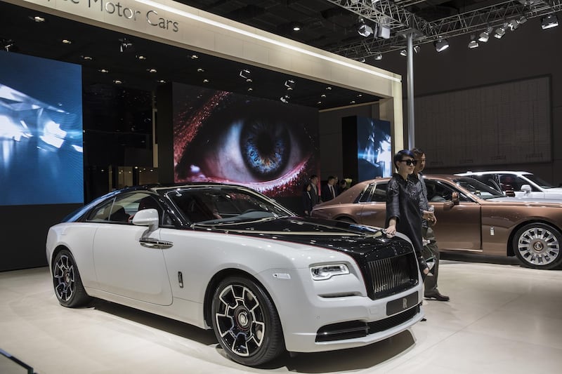 Attendees pose for photographs at the Rolls-Royce Motor Cars Ltd. stand at the Auto Shanghai 2019 show in Shanghai, China, on Thursday, April 18, 2019. China's annual auto show, held in Shanghai this year, opened to the media on April 16 amid the specter of an electric-car bubble and as the world's largest auto market trudges through its first recession in a generation. Photographer: Qilai Shen/Bloomberg