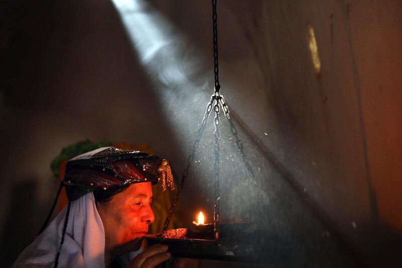 An Iraqi Yazidi woman prays at the Temple of Lalish, in a valley near the Kurdish city of Dohuk about 430km northwest of the capital Baghdad, on July 16, 2019. AFP