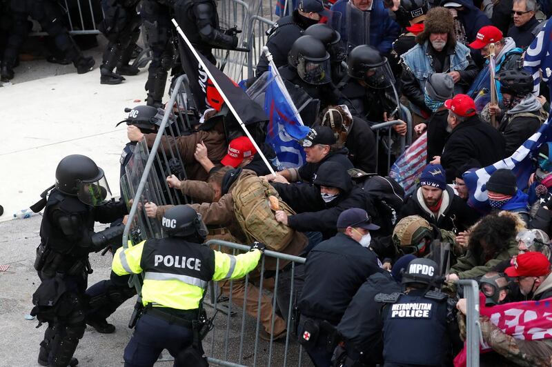 Pro-Trump protesters tear down a barricade as they clash with Capitol police during a rally to contest the certification of the 2020 US presidential election results by the US Congress. Reuters