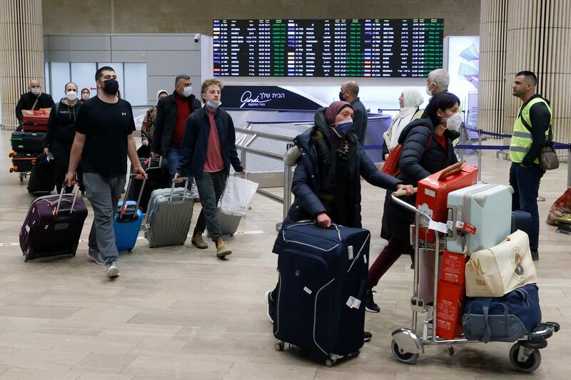 Passengers arrive at Israel's international airport near Tel Aviv on March 1, 2022. AFP