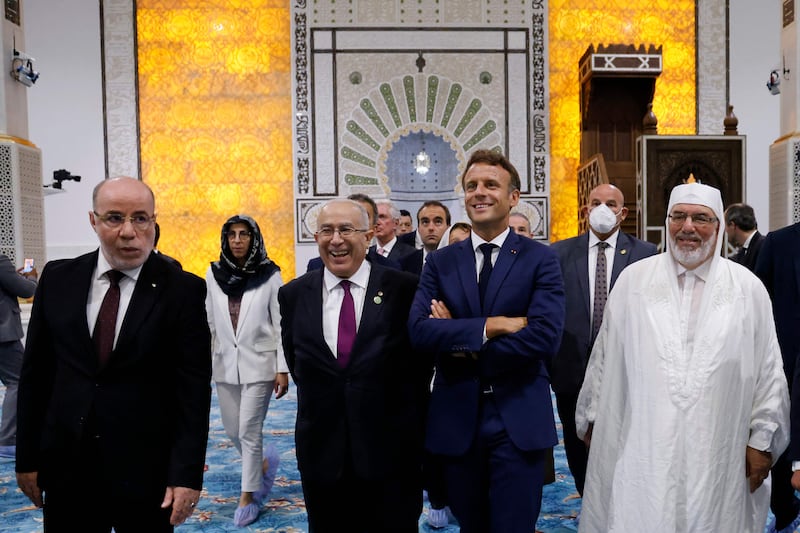 Mr Macron, Algerian Foreign Affairs Minister Ramtane Lamamra, second left, and the imam during the tour of the Great Mosque. AFP