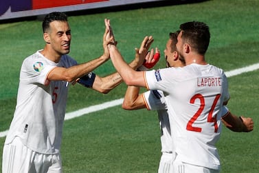 Spain's midfielder Sergio Busquets (L) and teammates celebrate scoring their team's first goal, an own goal scored by Slovakia's goalkeeper Martin Dubravka during the UEFA EURO 2020 Group E football match between Slovakia and Spain at La Cartuja Stadium in Seville on June 23, 2021. / AFP / POOL / Julio MUNOZ