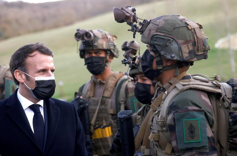 French President Emmanuel Macron (L) speaks with a soldier during a visit to the training centre of the 4th Regiment of the French Foreign Legion, in Saint-Gauderic, southern France, on March 12, 2021. - The French president presented decrees of naturalisation to five legionnaires during the ceremony. (Photo by STEPHANE MAHE / POOL / AFP)