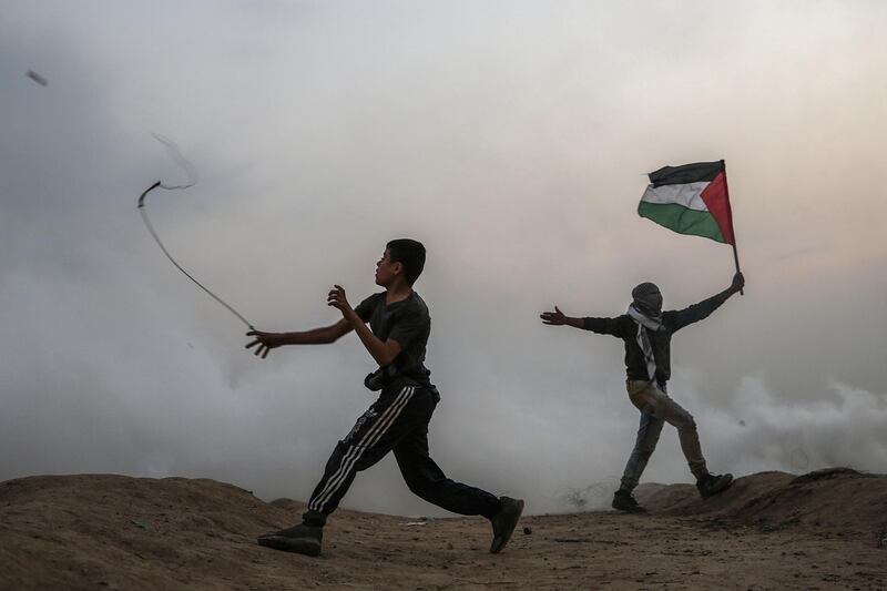 epaselect epa07199867 A Palestinian protester throws stones at Israeli troops during the clashes after Friday protests near the border between Israel and Gaza Strip in the east Gaza Strip, 30 November 2018. Protesters plan to call for the right of Palestinian refugees across the Middle East to return to homes they fled in the war surrounding the 1948 creation of Israel.  EPA/MOHAMMED SABER