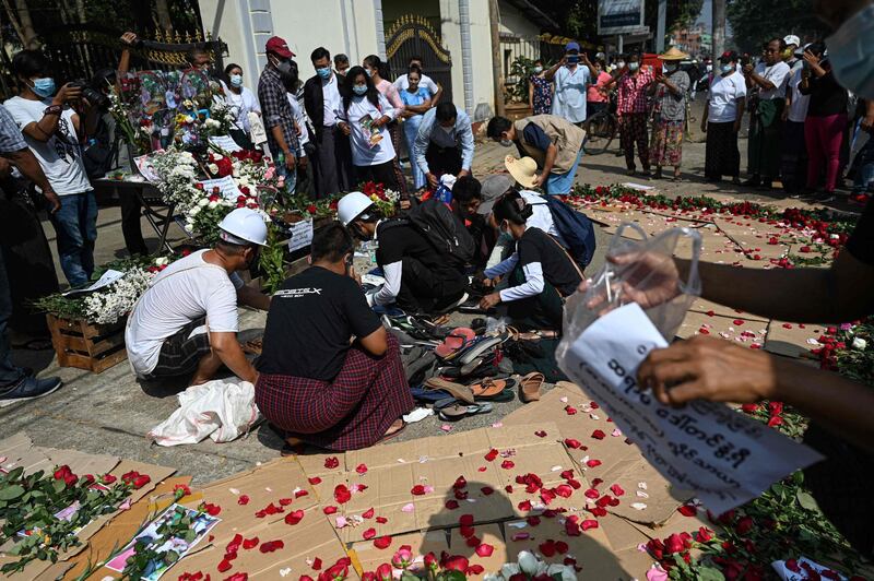 Protesters arrange abandoned flip flops and other belongings next to a makeshift altar for teacher Tin Nwe Yi left behind during a crackdown in Yangon after she was killed during a demonstration against the military coup.  AFP
