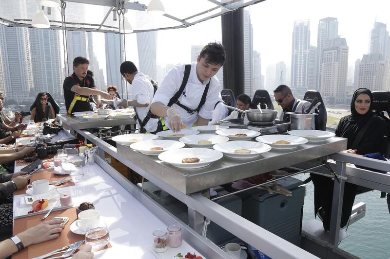 Senior chef from the Ritz Carlton, Elgin Alonso, prepares the brunch meal for serving alongside his colleagues during Dinner in the Sky over Dubai. Jeffrey E Biteng / The National 