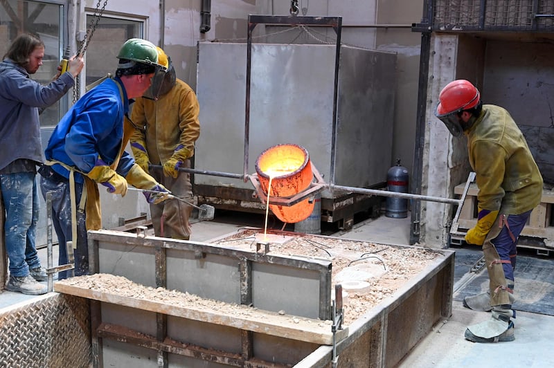 Sculptor Gilly pouring molten bronze in to a mould for the statue