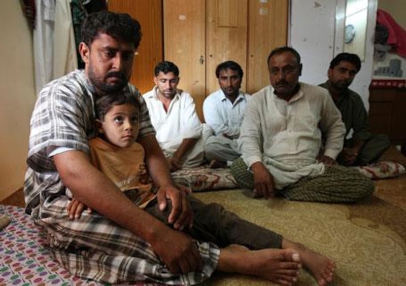 Mukhtiar Ahmed Khudabaksh, left, with his seven-year-old son Mustaffa and relatives at his home in Dubai.