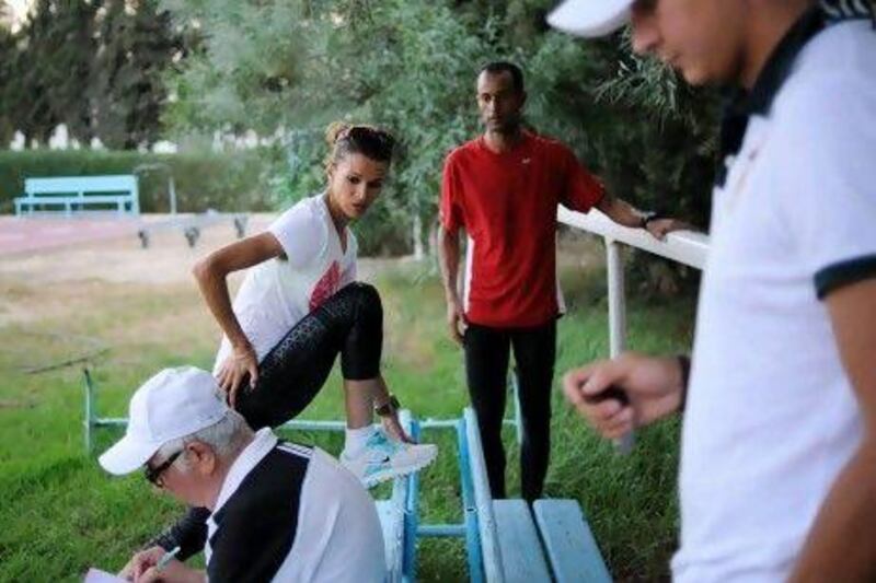 Tunisian athlete and Olympic silver medalist Habiba Ghribi stretches while training at a stadium in downtown Tunis. At the London Olympics, some religious groups criticised her online for wearing clothes they considered too revealing.