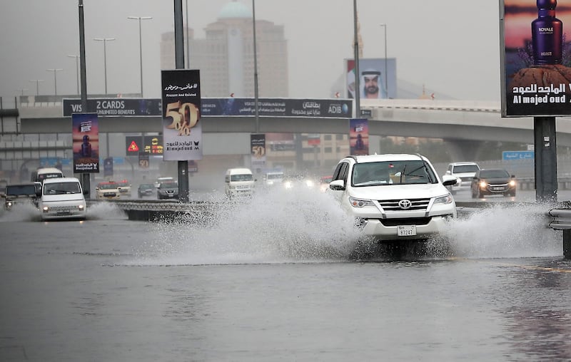 Traffic ploughs through the heavy rain and flood water on Sheikh Zayed road in Dubai. Pawan Singh / The National 
