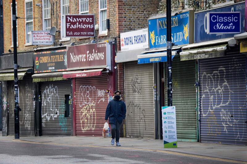 (FILES) In this file photo taken on November 10, 2020 a man walks past closed shops in London on November 10, 2020. Britain's unemployment rate hit 5.0 percent at the end of 2020, the highest level for more than four-and-a-half years, as coronavirus lockdowns destroyed jobs, official data showed on January 26, 2021. / AFP / Tolga Akmen
