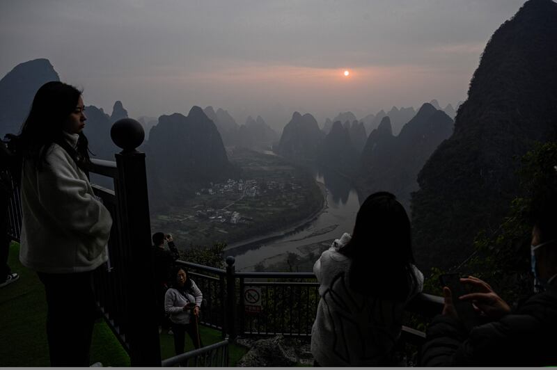 Tourists watch the sunrise on Xianggong Mountain, on the west bank of Li River in Yangshuo city, in southern China's Guangxi province. AFP