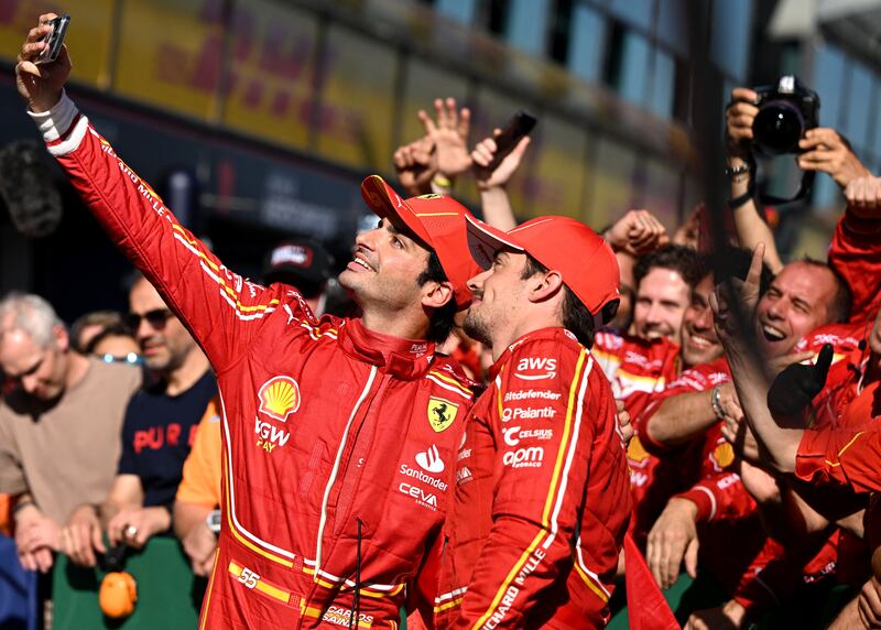 Carlos Sainz and Charles Leclerc take selfies after Ferrari's 1-2 finish at Albert Park. Reuters